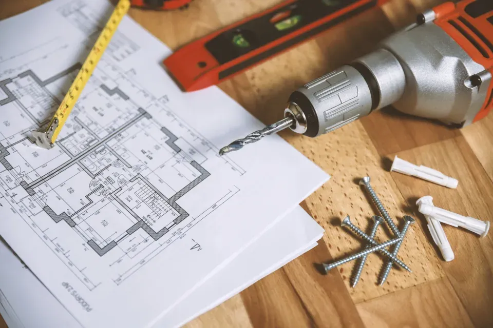 Building plans with a drill and tape measure