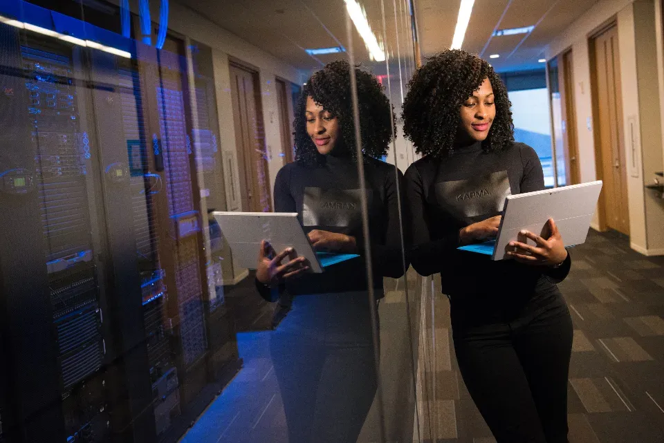 Two engineers with laptops in a server room