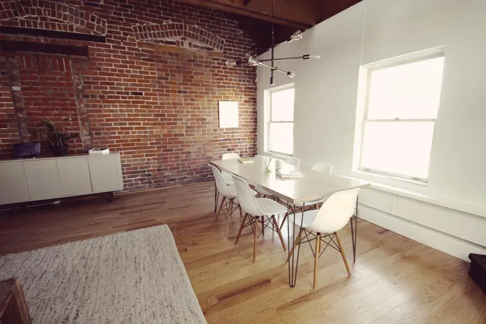 Bright office with a long table and brick wall