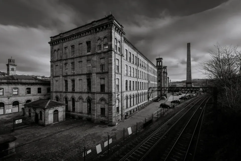 Old Victorian mill building beside a railway line