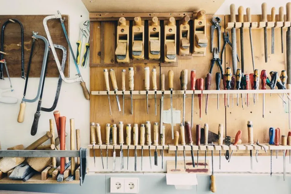 Hand tools arranged on a workshop pegboard