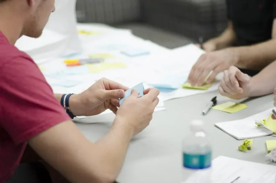 Team arranging sticky notes on a table during planning
